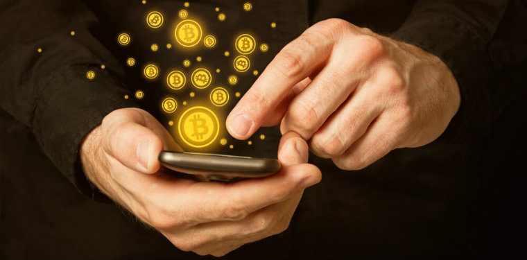 pessoa usando seu celular. enquanto sua mão clica na tela, moedas de bitcoin são lançadas para fora do aparelho, representando o mundo do blockchain e hashgraph
